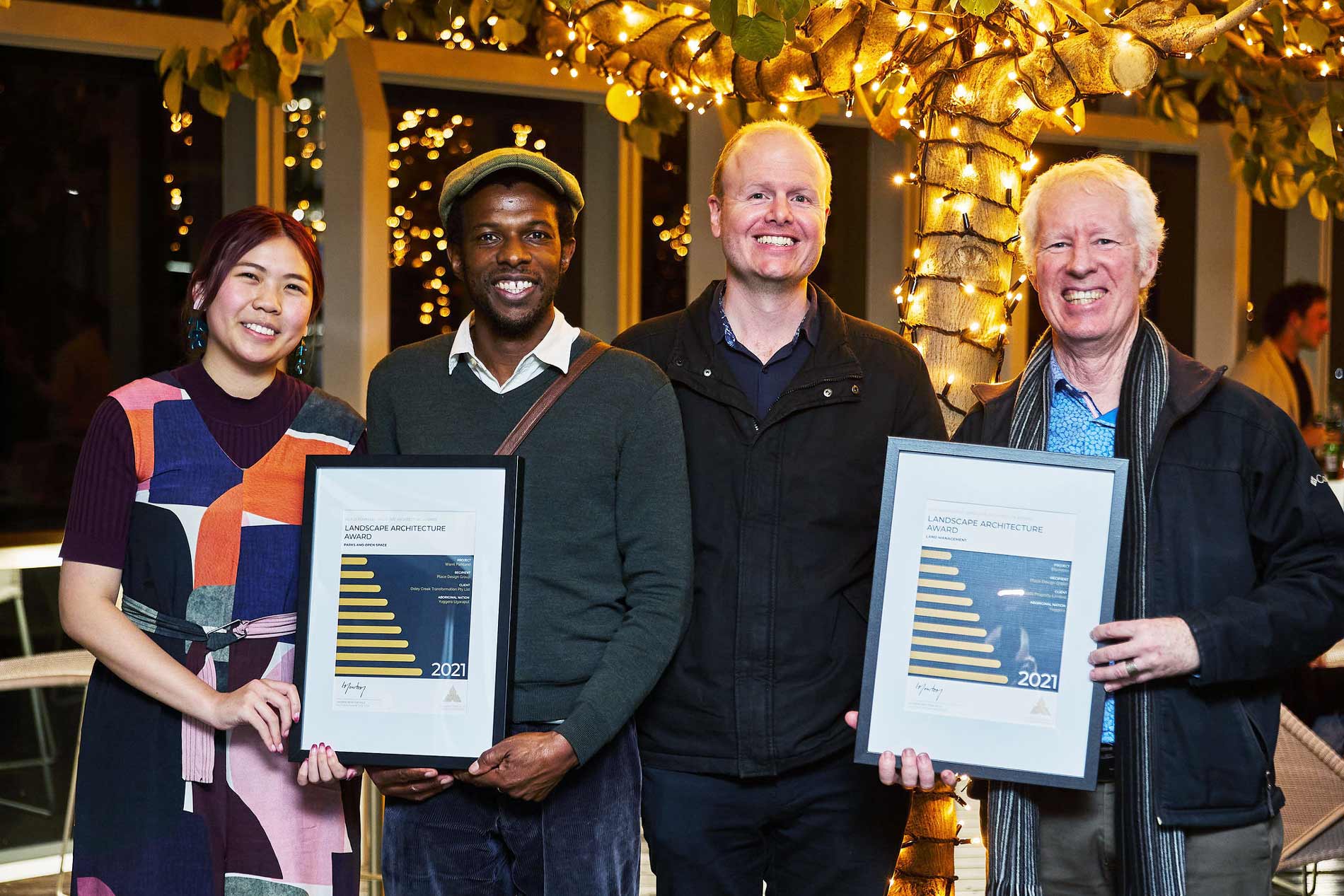 4 people posing with awards