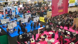 Busy exhibition floor at Futurebuild London, showcasing booths, networking areas, and speaker sessions attended by architecture, engineering, and construction professionals.