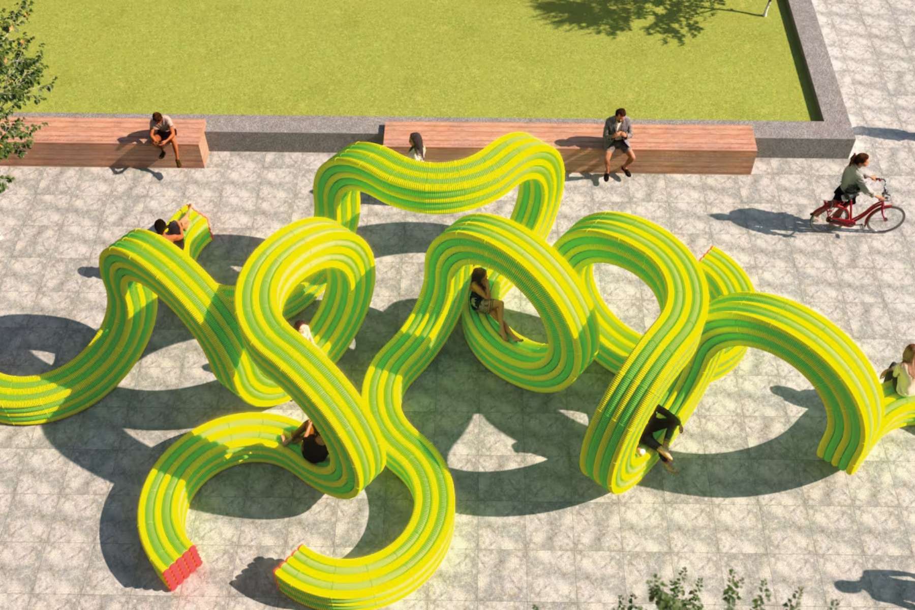 An artistic public seating installation featuring a winding, snake-like structure in bright yellow-green, with people sitting along its curves and wooden benches nearby.