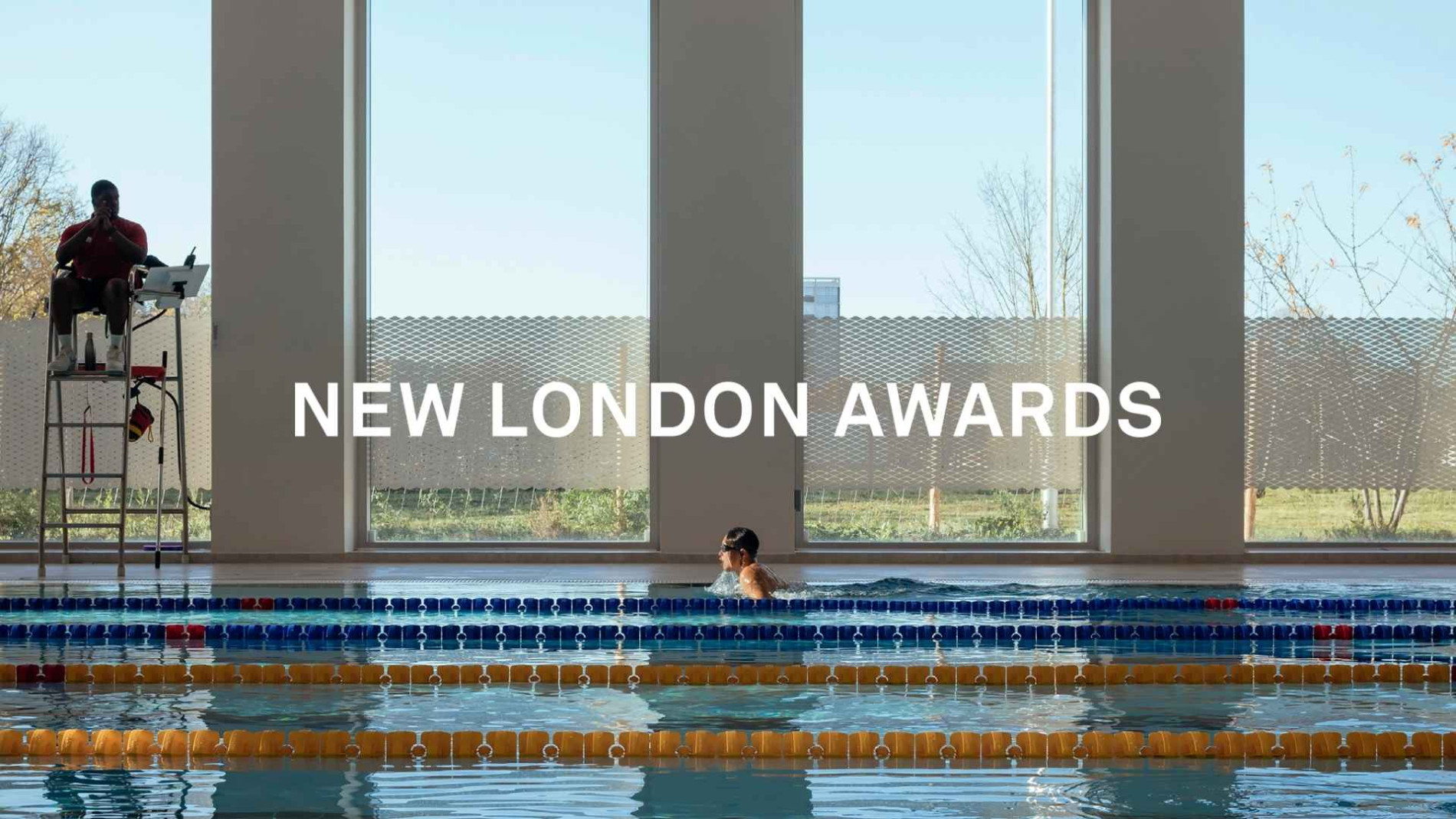 Boy swimming in pool with beautiful landscape through the windows. White bold text reads "New London Awards"