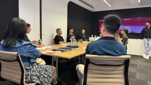 Meeting in conference room with black walls and wooden table