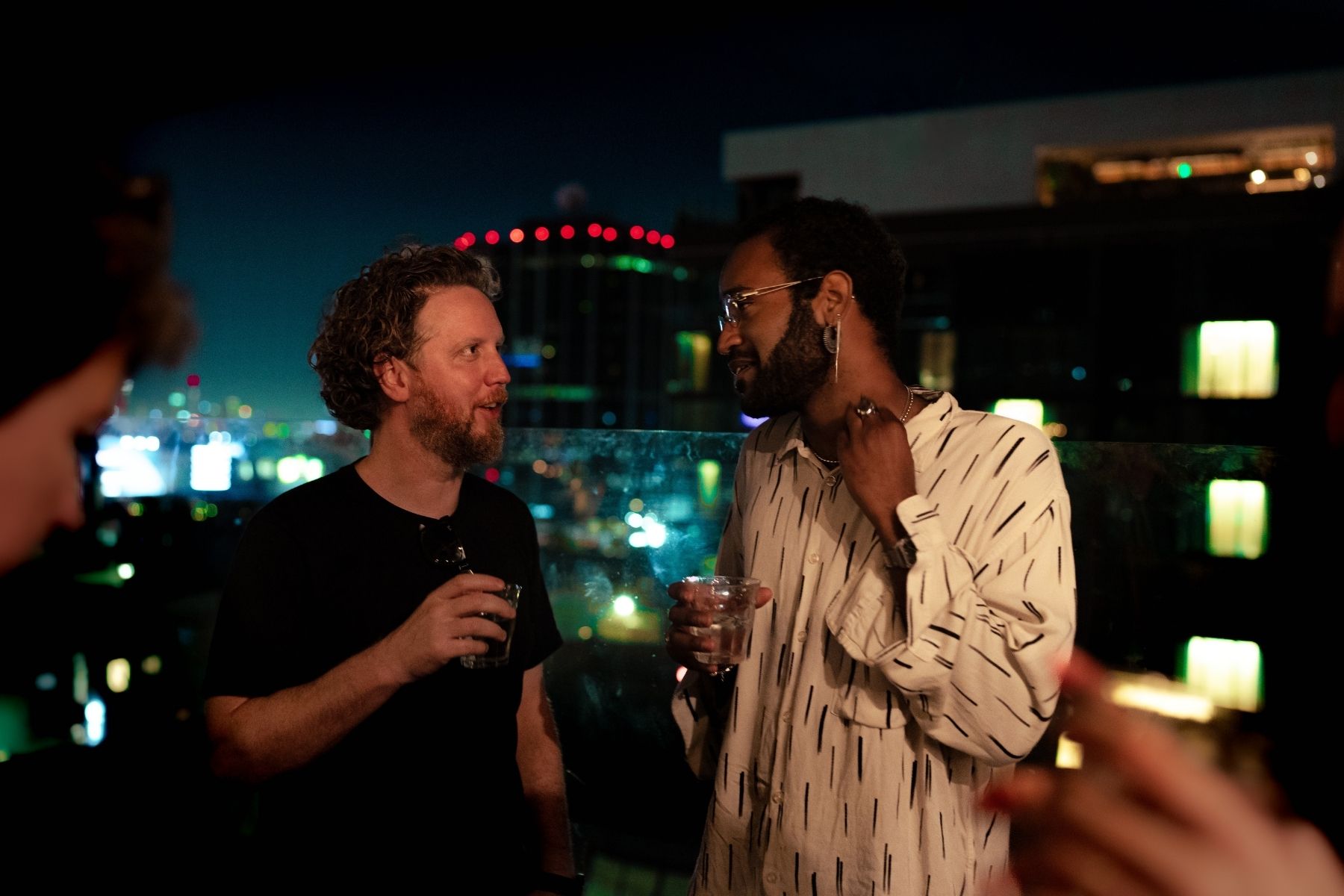 Two people in discussion at an event over drinks