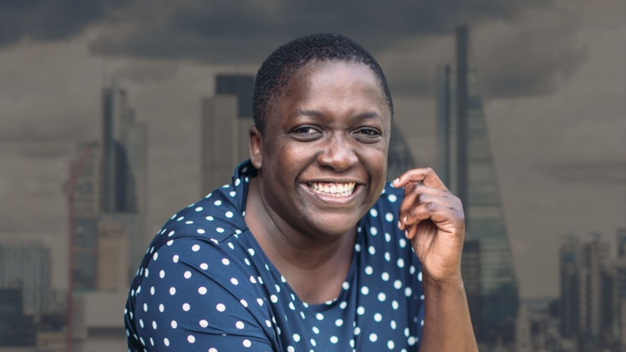 Profile of Ayo Abbas. She has short dark hair and is smiling at the camera. The background is the London skyline.