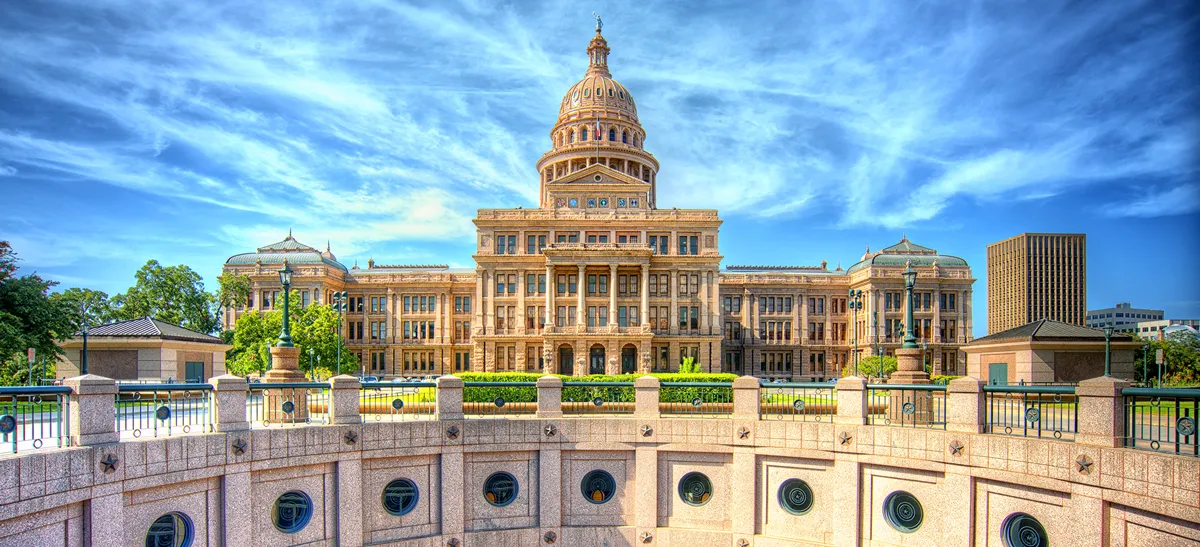 The iconic Texas State Capitol building with its distinctive dome and surrounding grounds