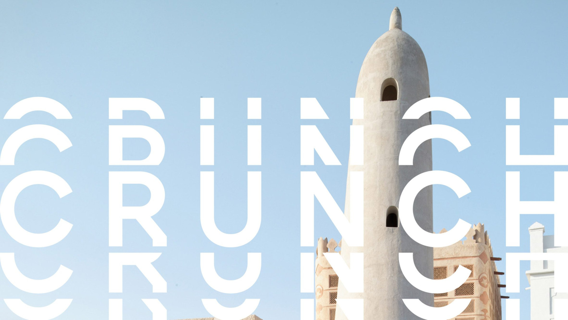 Modern architectural structure in Bahrain with a clear blue sky, showcasing a traditional tower design alongside geometric text elements reading 'CRUNCH.