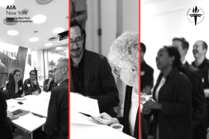 Black-and-white photo showing participants engaged in discussions during the AIA New York Torch Mentoring Program. The image highlights a collaborative environment with individuals seated and standing, reviewing documents and interacting at the event. 