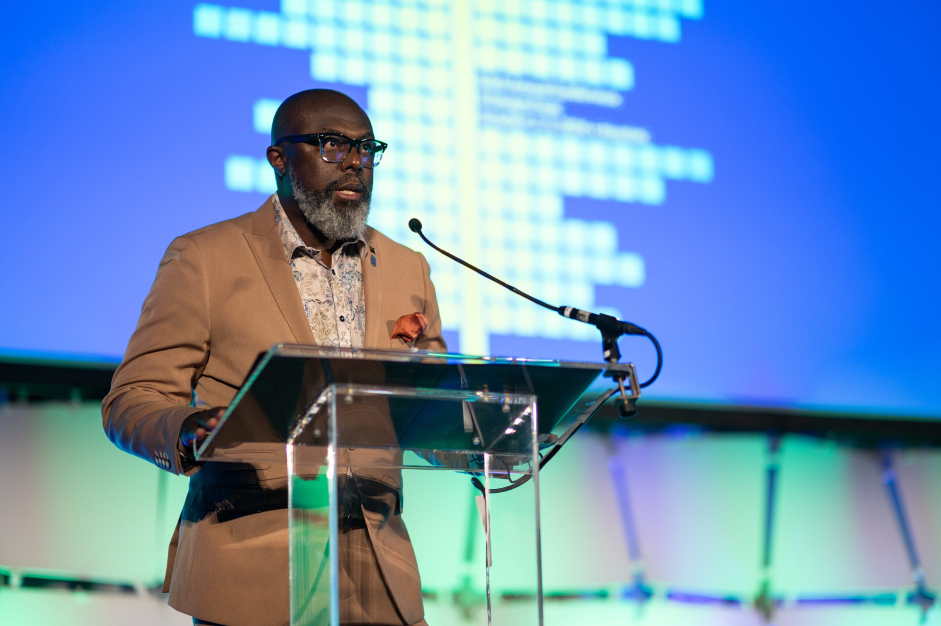 Man speaking on stage at conference