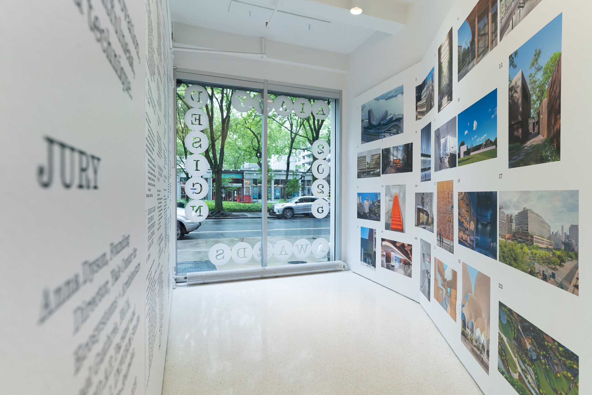Image of the inside of the exhibition. White walls and glass door that leads to street.