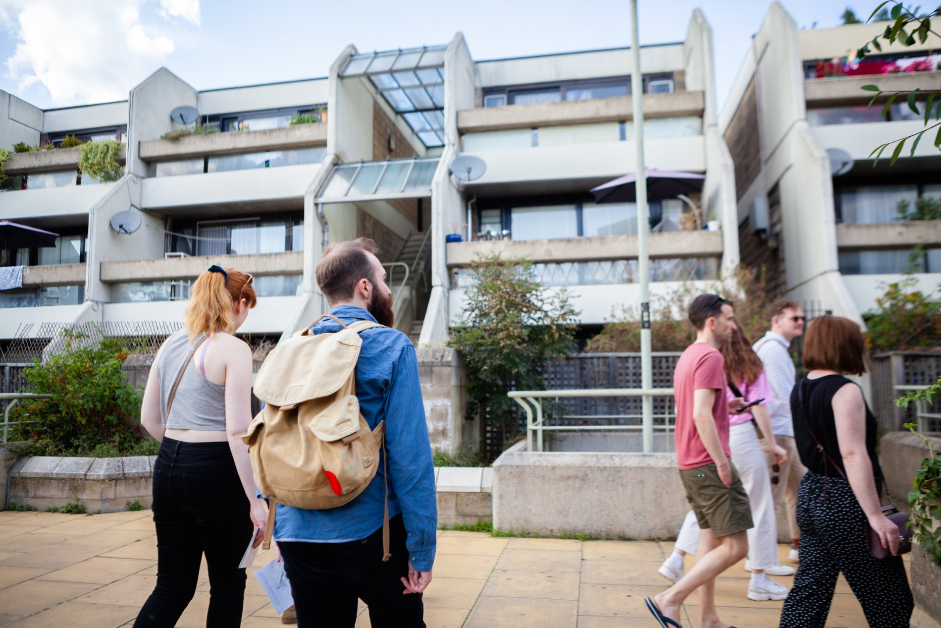 People walking around a brutalist.