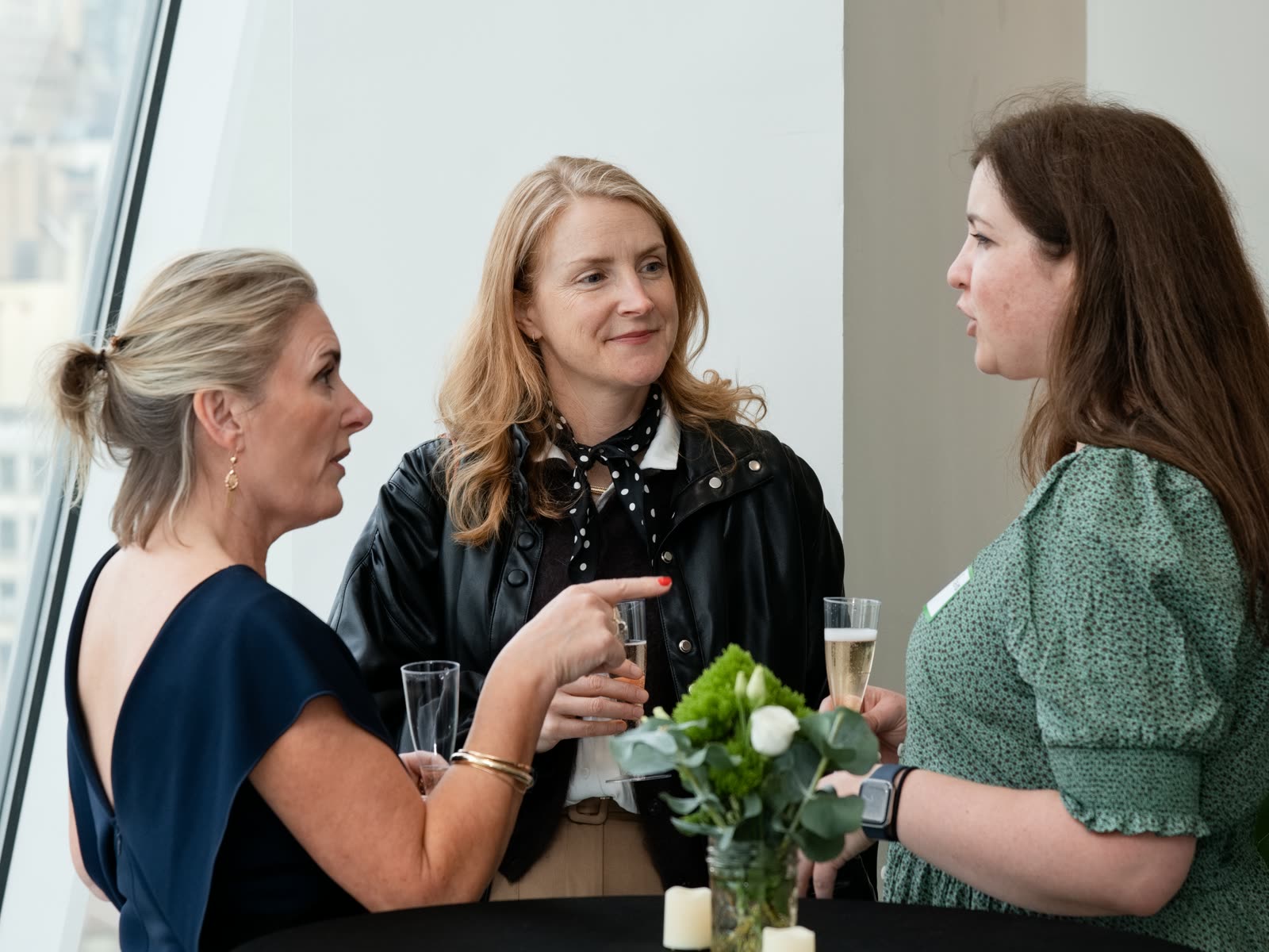Three guests talking over drinks at the Bespoke New York office launch