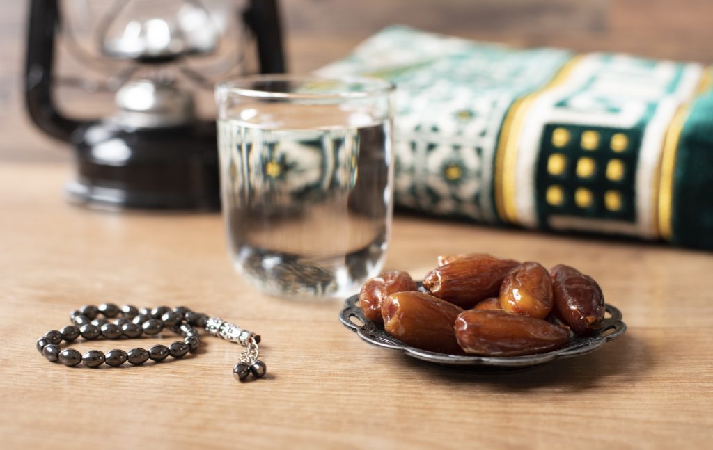 Water and dates. Iftar is the evening meal. View of decoration Ramadan Kareem holiday carpet background