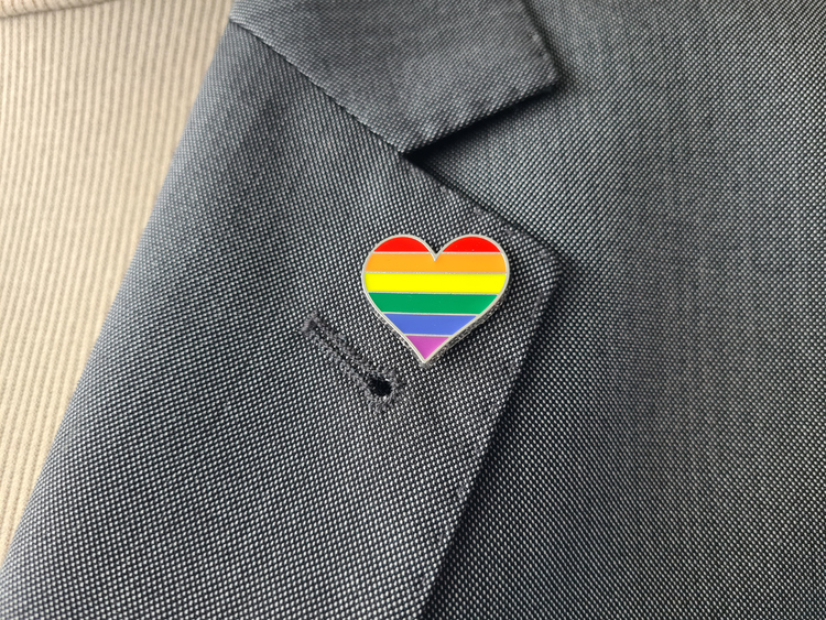 Closeup of LGBT flag pin attached to business suit. LGBT rights concept