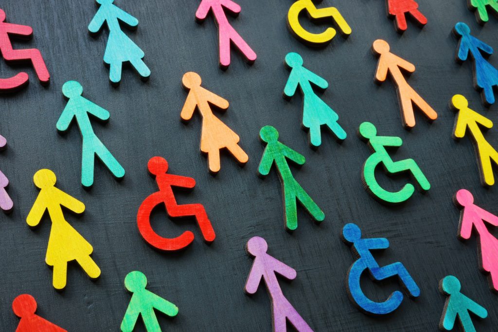 A image of multi-coloured stick men symbols. Amongst the stick men are symbols of a person in a wheelchair.